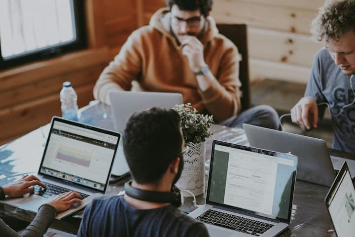 Developers collaborating on laptops while building an AI agent