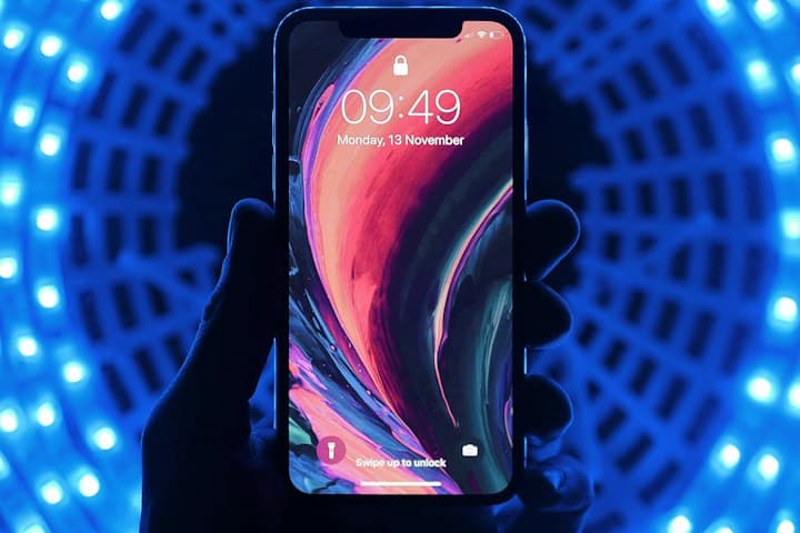 Hand holding a smartphone lit by blue light rings